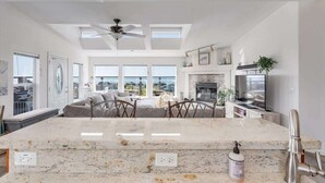 A modern kitchen with a large island, skylights, a fireplace, and a television. - Bodega Bay Oasis  - Wine Tastings Included (Bodega Bay)