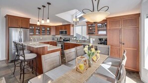 A modern kitchen with wooden cabinets, stainless steel appliances, and a central island. - Bodega Bay Oasis  - Wine Tastings Included (Bodega Bay)
