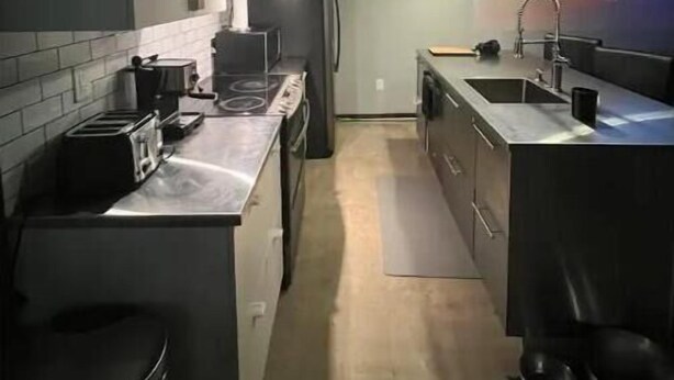 A narrow kitchen with a toaster, a coffee maker, and a refrigerator. - Premier Loft Downtown Detroit (Detroit)