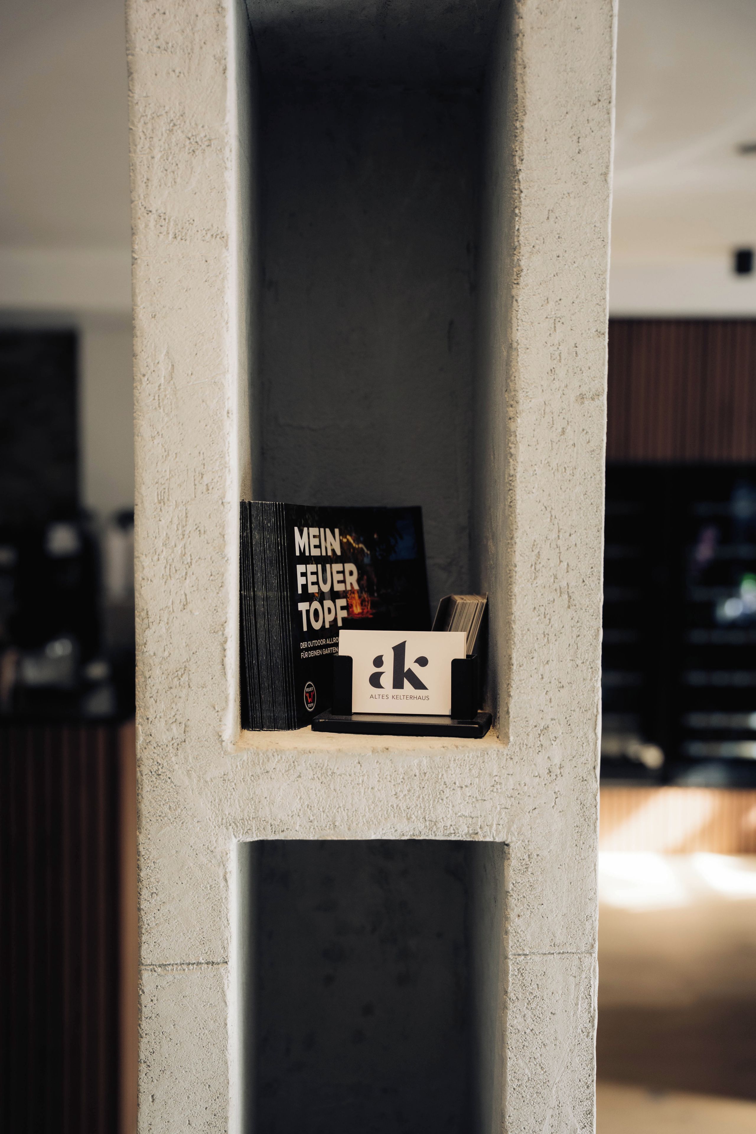 Una estantería con libros y una pequeña caja negra.