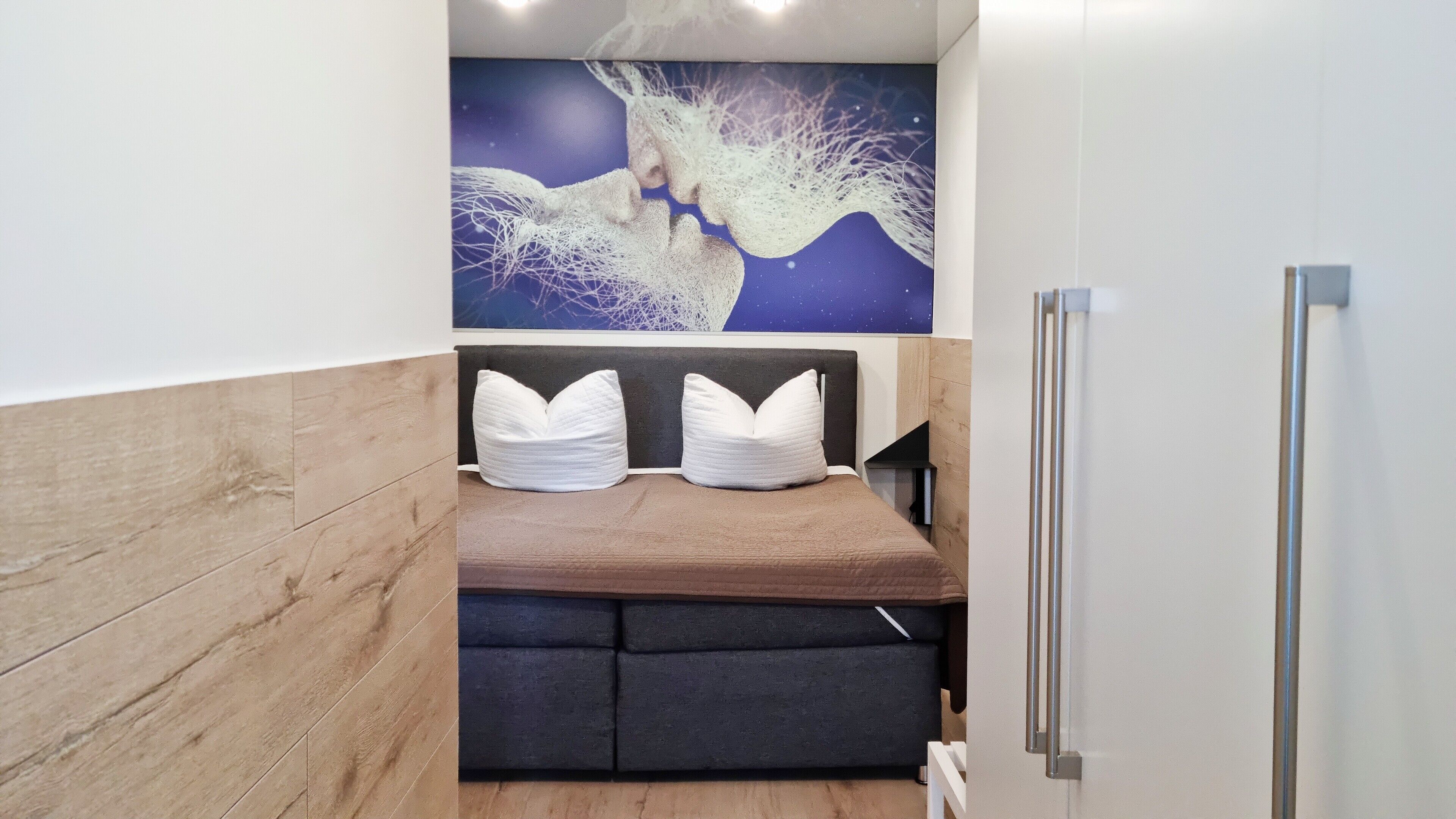 A modern bathroom with a wooden vanity, a bench with cushions, and a wall-mounted mirror.