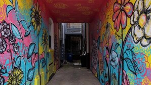 A tunnel with colorful murals on the walls and a red ceiling. - Hotel Quality/ Walkable / Free Parking/ Office #11 (Lakewood)