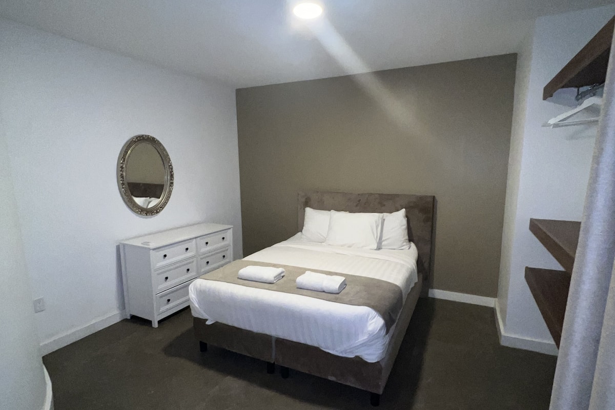 A bedroom with a bed, dresser, and mirror.