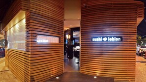 A sushi restaurant with a modern wooden facade and a sign that reads "sushi + leblon". - Studio Bartho Leblon (Leblon Rio de Janeiro)