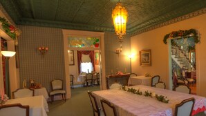 A dining area with a large table set for a meal, surrounded by chairs.