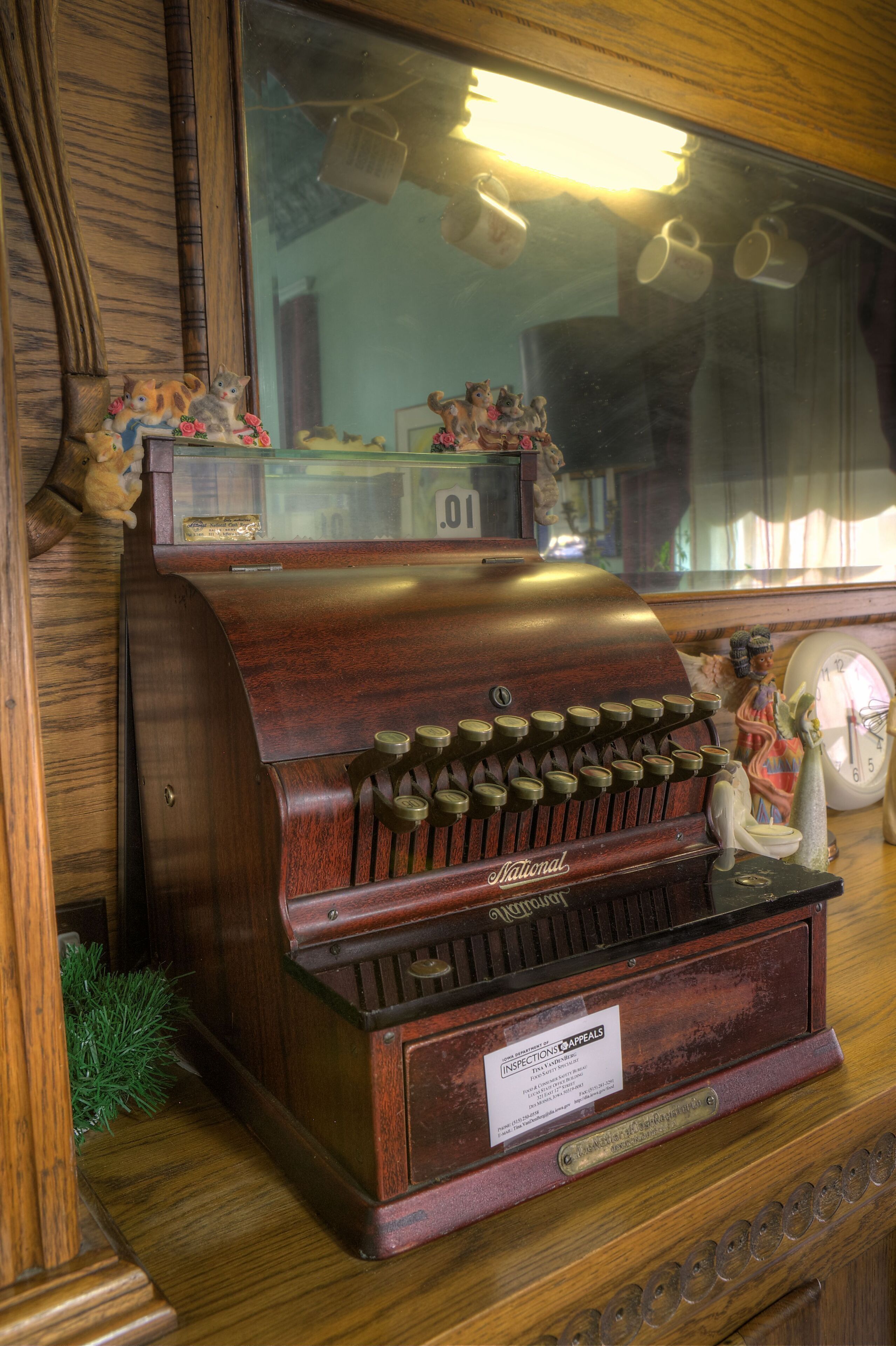 A vintage jukebox with a brass plaque, a clock, and decorative items on a wooden surface.