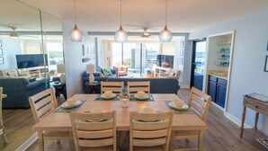 A dining area with a table set for four, a sofa, and a view of the cityscape. - Whoa!  Amazing view!! (Myrtle Beach)