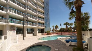 A hotel with a swimming pool, multiple balconies, and a palm tree. - Whoa!  Amazing view!! (Myrtle Beach)