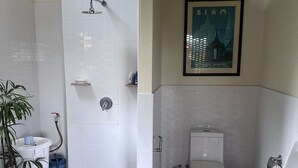 Un baño con ducha, inodoro, lavamanos y un cuadro en la pared.