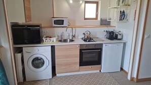 A compact kitchenette with a microwave, toaster, kettle, sink, and a washing machine. - Le Houx Blanc: Stylish 3 star apartment with pool, private jacuzzi and terrace (Mantilly)