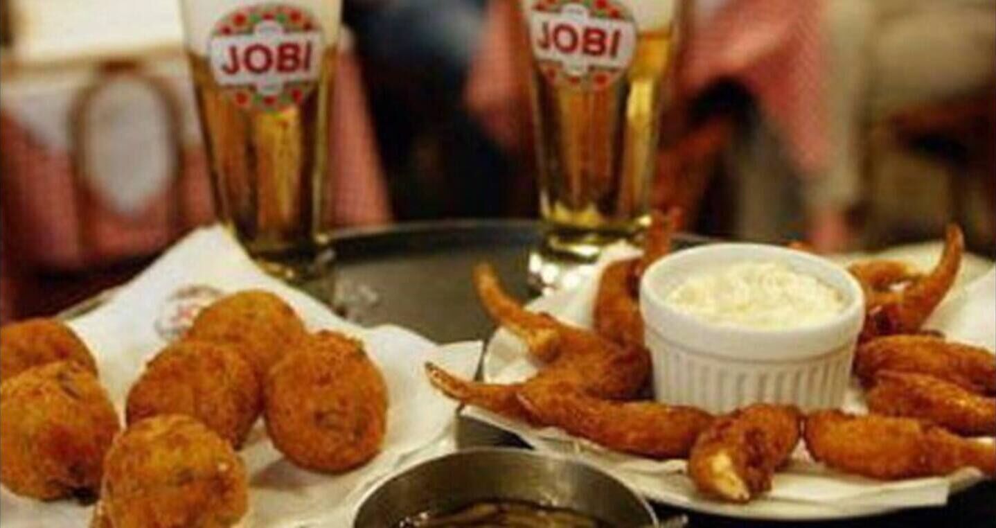 En bord med friturestegt mad og to glas øl mærket 'JOBI'.