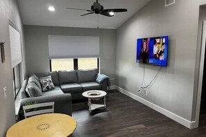 Relax in this stylish living room with a sofa, coffee table, and flat-screen TV.