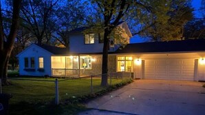 Una casa residencial con garaje, porche delantero y césped bien cuidado.