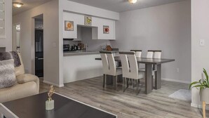 Ein modernes Wohnzimmer mit Essbereich, Küche und Treppe.