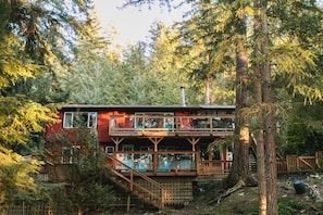 Eine Holzhütte mit einer Veranda und einer Treppe, die zu einer zweiten Etage führt.