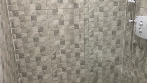 A shower area with a tiled wall and a white bathtub. - City Centre Skyline - Private Room with shared bathrooms  (dublin)