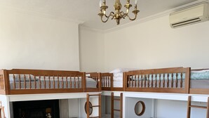 A room with bunk beds, a chandelier, and a round wooden table with red chairs. - City Centre Skyline - Private Room with shared bathrooms  (dublin)