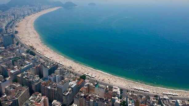 An aerial view of a coastal city with a long beach, dense urban area, and prominent mountains in the background. - Fullano B&B (Rio de Janeiro)