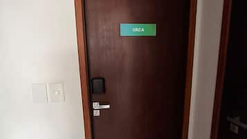 Une porte en bois fermée, sur laquelle on peut lire l’inscription « URCA », avec une poignée de porte et un trou de serrure.