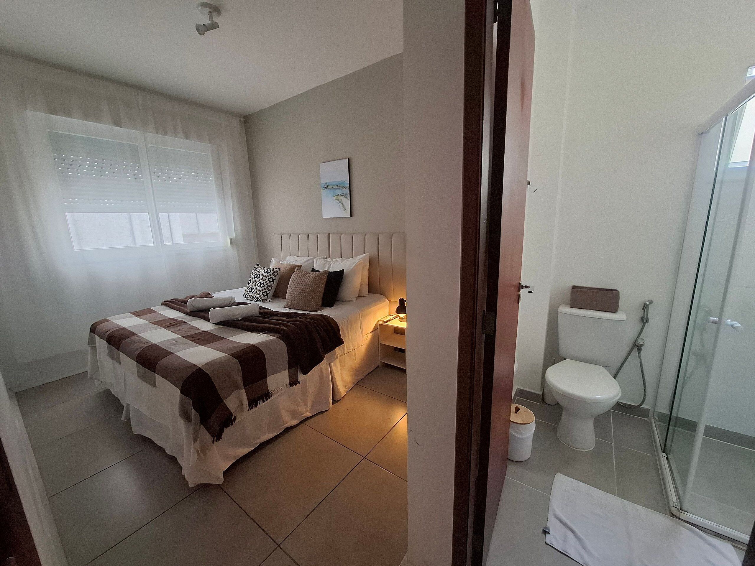 Une chambre à coucher avec un lit, une table de chevet et une fenêtre.