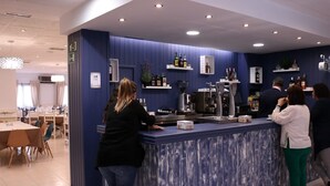 Un espace bar avec un mur d’accent bleu, un comptoir et des étagères remplies de bouteilles.