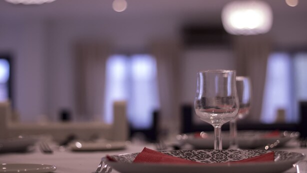 Une table à manger dressée avec des assiettes, des verres et une serviette rouge.