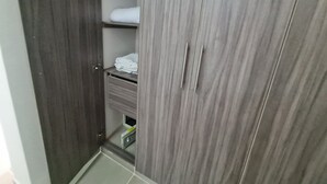 Um guarda-roupa com espelho e prateleira com roupas dobradas.