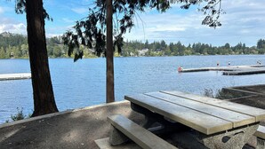 Ein Picknickplatz am Seeufer mit Bänken und einem Steg.
