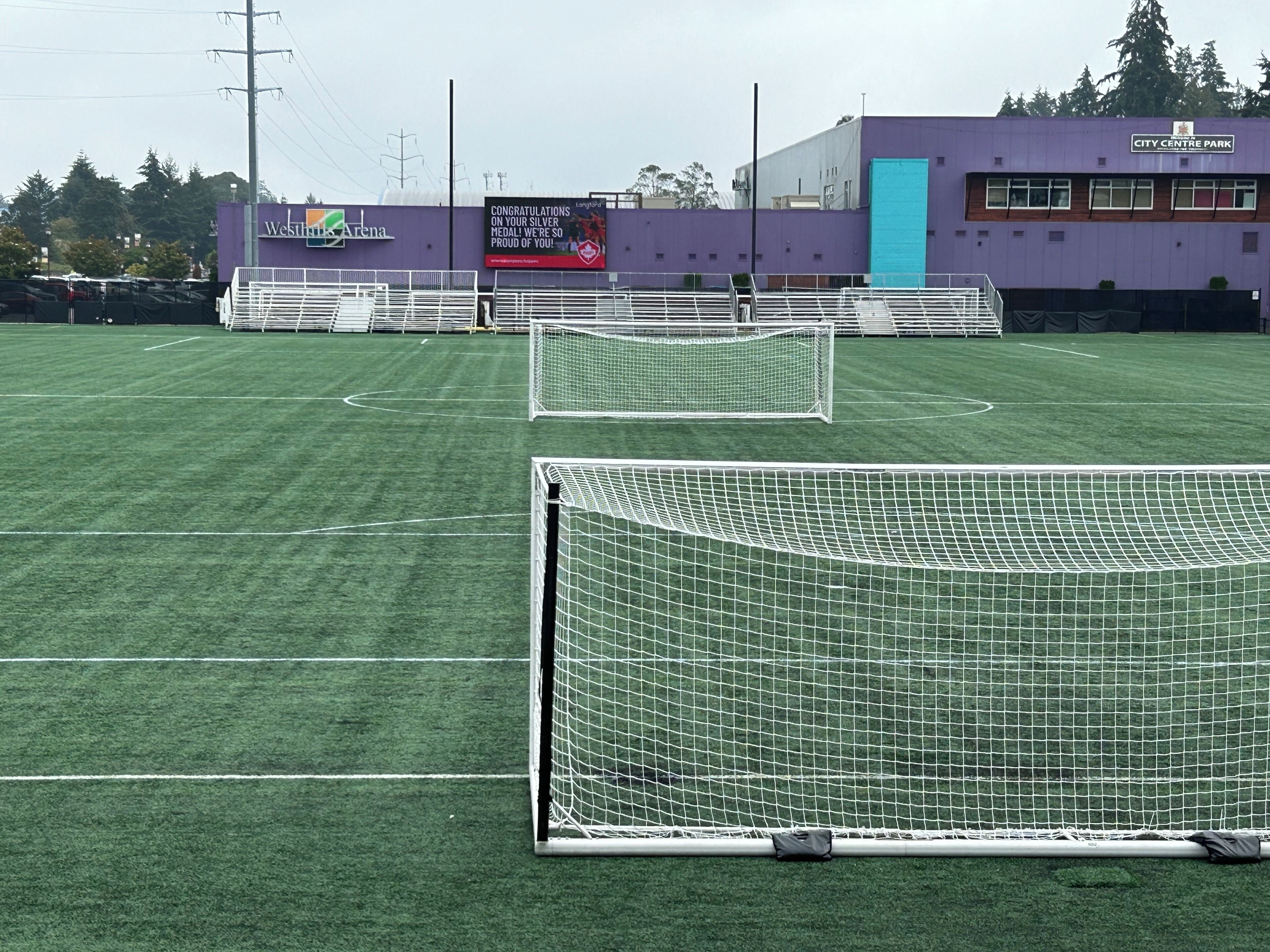 A soccer field with goalposts and bleachers.