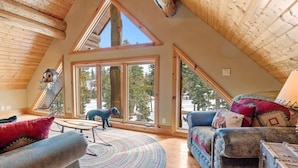Un loft espacioso con techos altos, ventanas amplias y una zona de estar acogedora con un perro.