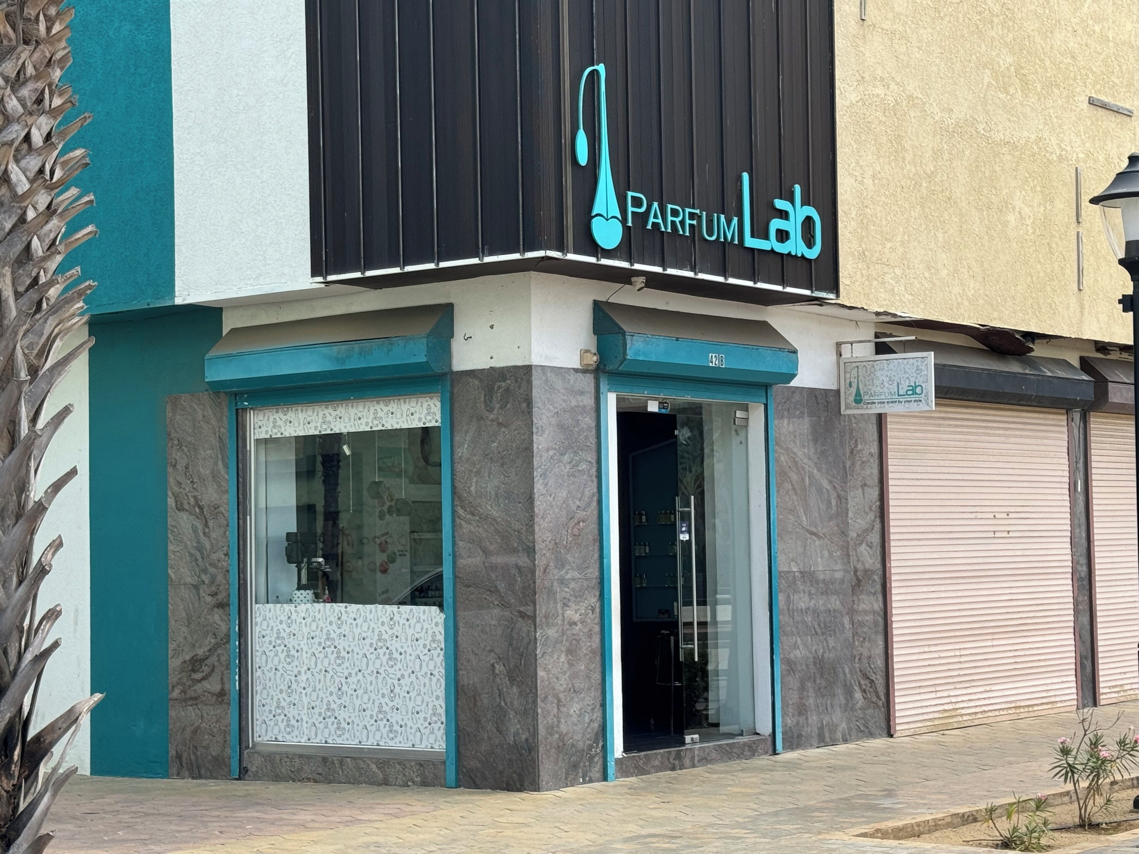 A building with a sign reading "Parfum Lab" and a number "42" above the entrance.
