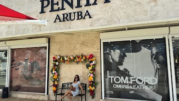 A storefront with the sign "PENHA ARUBA" and a floral arch decoration.