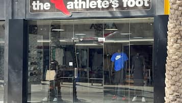 Una tienda con un amplio escaparate de vidrio que muestra zapatillas deportivas y ropa.