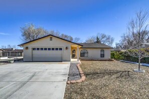 A single-story house with a garage, a small attached structure with a window, and a gravel driveway.
