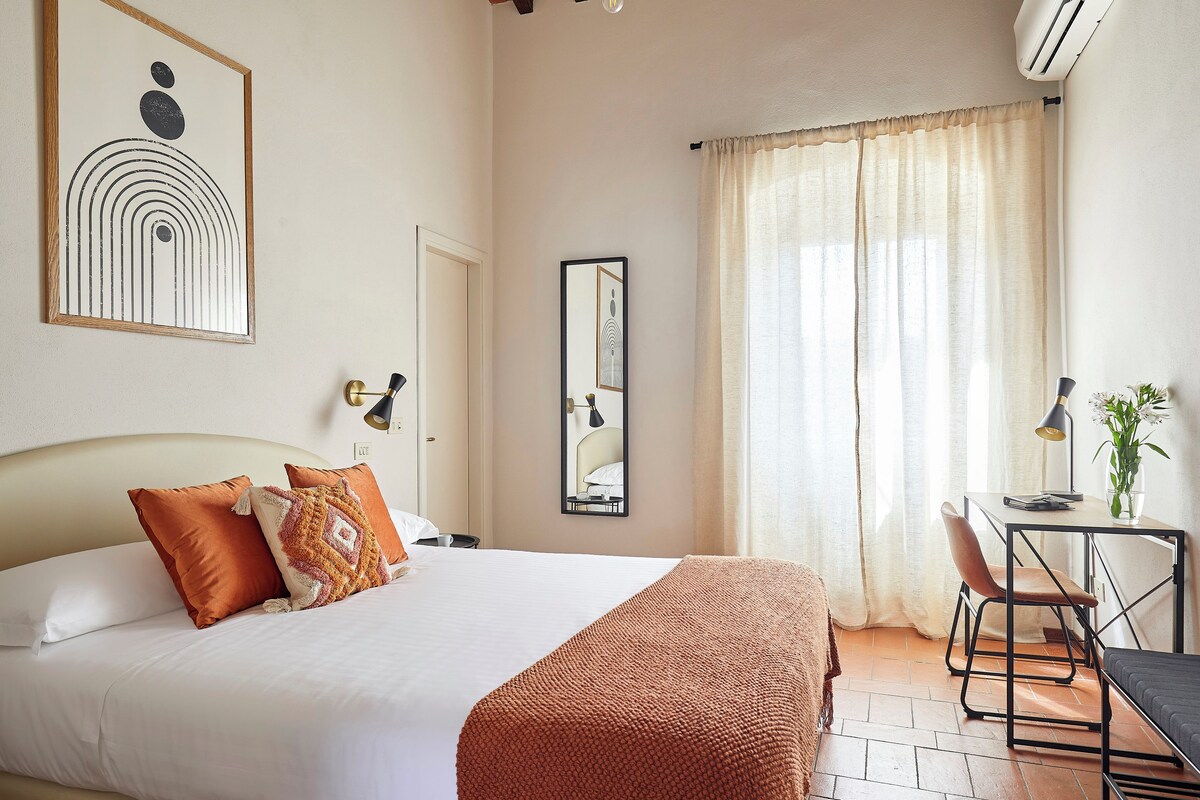 Una habitación de hotel con una cama, un escritorio y una silla.