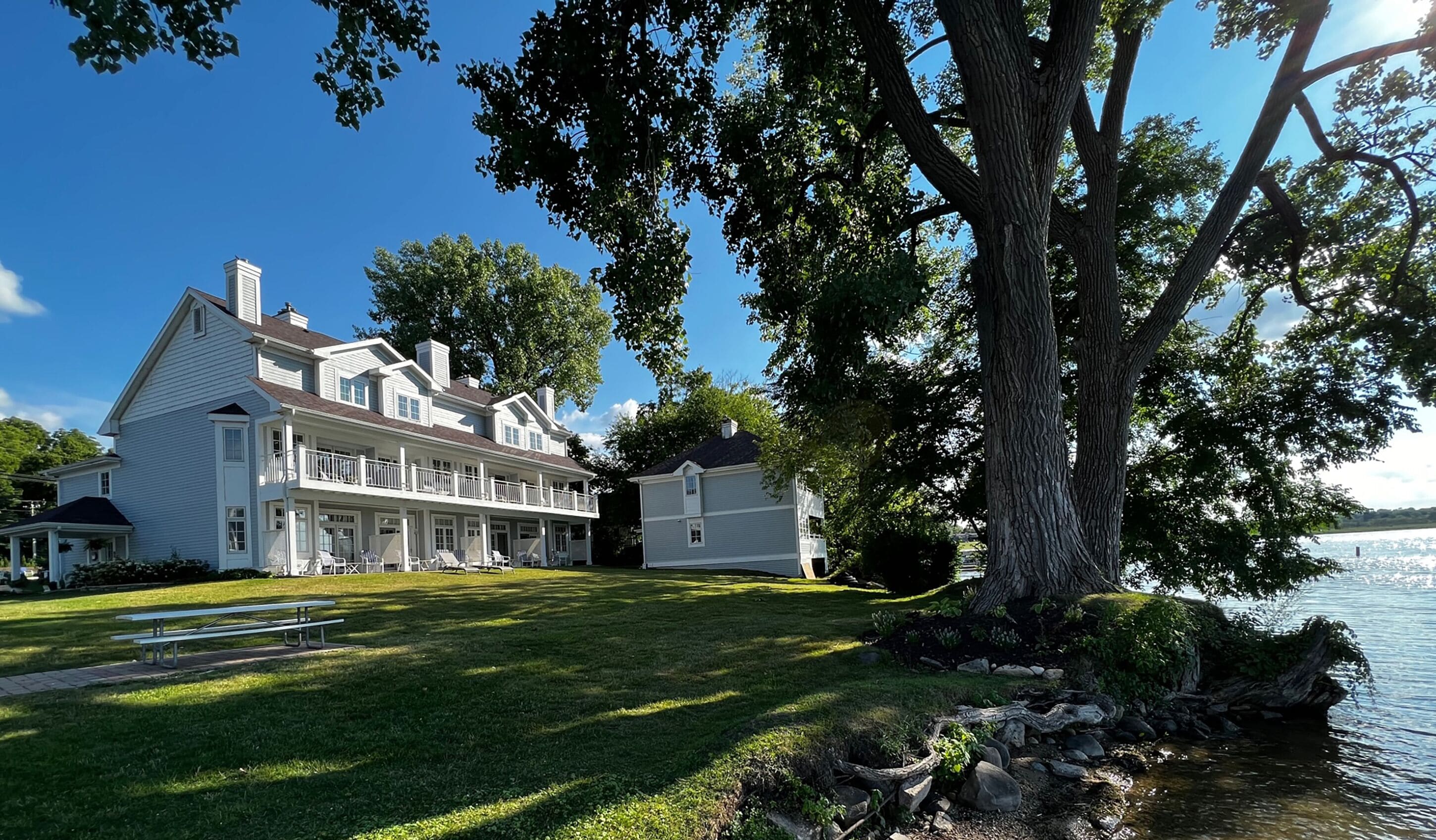 A large, two-story house with a covered porch and a lawn.