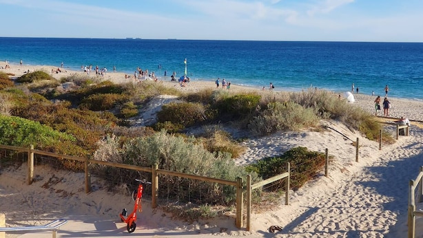 A beach with people, a red scooter, and a flagpole. - Coastal Salty Kiss Sleeps 4! (Scarborough)