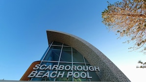 The exterior of Scarborough Beach Pool with a modern architectural design and large glass windows. - Coastal Salty Kiss Sleeps 4! (Scarborough)