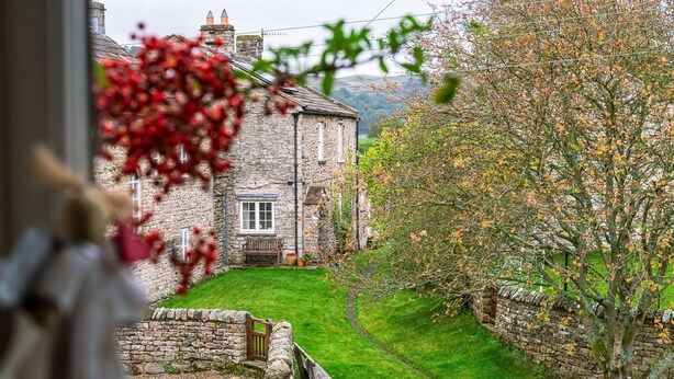 A stone building with a grassy yard and a tree with autumn leaves. - A dales bolthole & quintessential country cottage – cosy, appealing & in an idyllic rural setting (Richmond)