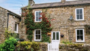 A stone house with a white door, windows, and a white picket fence. - A dales bolthole & quintessential country cottage – cosy, appealing & in an idyllic rural setting (Richmond)