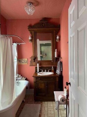 Relax in a vintage-style bathroom with a clawfoot bathtub, wooden vanity, and mirror.