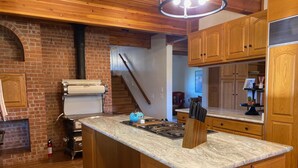 A kitchen with wooden cabinets, a marble countertop, and a built-in stove.
