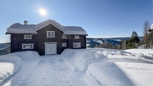 A wooden house with a white door and windows, surrounded by snow and mountains in the background. - Gorgeous home in Svatsum with WiFi (Svatsum)