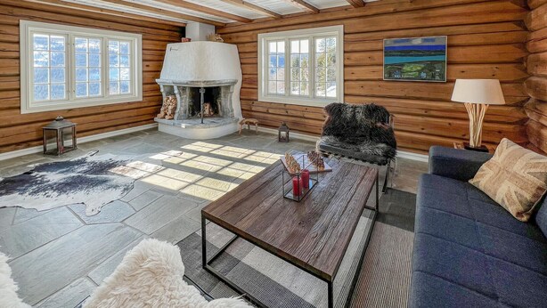 A log cabin interior with a fireplace, a sofa, a coffee table, and a painting on the wall. - Gorgeous home in Svatsum with WiFi (Svatsum)