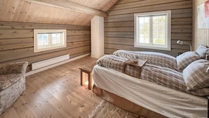 A cozy cabin-style bedroom with a wooden ceiling, two windows, a bed with plaid bedding, and a small table with a cup and saucer. - Gorgeous home in Svatsum with WiFi (Svatsum)