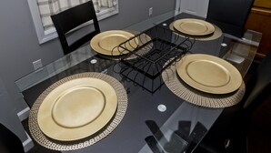 Een eettafel met vier beige borden en een zwarte metalen mand.