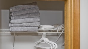 Een kast met netjes opgevouwen handdoeken en ophanghaakjes.