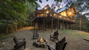Een chalet met een terras, een vuurkuil en zitplaatsen buiten.