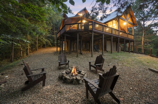 Une cabane dotée d’une terrasse, d’un foyer extérieur et de sièges pour profiter de l’extérieur.