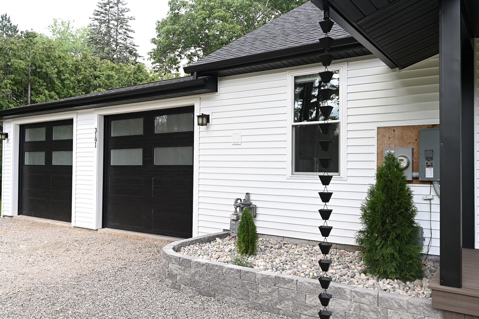 A two-story building with a garage and a small window.